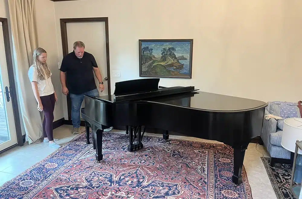 piano movers moving a used piano in a house